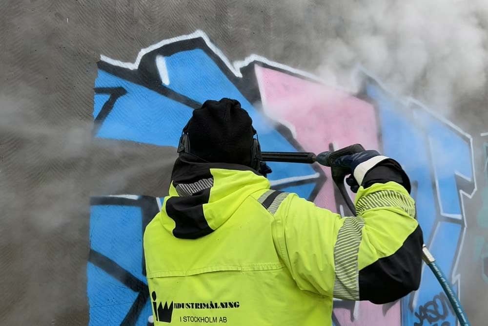 Borttagning av klotter på en vägg utomhus